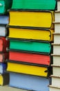 Many multi-colored books are stacked on top of each other in the glass showcase of a bookstore. Collection of old books