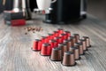 Many multi-colored capsules for a coffee machine lie on a beautiful wooden table against the background of the kitchen Royalty Free Stock Photo