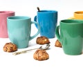 Many multi-colored mugs of lemon tea and homemade cookies on a white table. Royalty Free Stock Photo