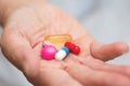 Many multi-colored pills in a Senior`s hands. Painful old age. Caring for the health of the elderly Royalty Free Stock Photo
