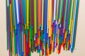 many multi-colored plastic tubes for cocktail on Colored background, top view Royalty Free Stock Photo