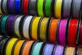 Many multi-colored spools coils of thread of filament for printing 3d printer.