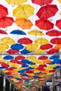 Many multi-colored umbrellas in the sky, unusual summer street scenery