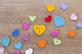 Many multicolor crochet hearts on wooden background for Valentines day