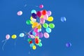 many multicolored balloons flying in the blue sky. Holiday accessories and decorations Royalty Free Stock Photo