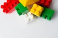 Many multicolored cubes of children`s constructor blocks on a white background top view with copy space. Concept Royalty Free Stock Photo