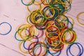 Many multicolored elastic rubbers on wooden table. Top view