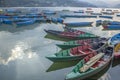 multicolored wooden boats on the lake against the backdrop of green mountains. blue red green yellow empty boats on the water Royalty Free Stock Photo