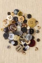 Pile of neutral brown buttons on hessian