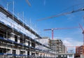 Many new houses are being built in Munich. A large construction site with new buildings and scaffolding, a road and many cranes Royalty Free Stock Photo