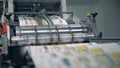 Many newspapers moving on typographic conveyor with a roller.