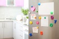 Many notes and empty sheets with magnets on refrigerator door in kitchen Royalty Free Stock Photo