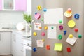 Many notes and empty sheets with magnets on refrigerator door in kitchen Royalty Free Stock Photo