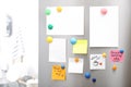 Many notes and empty sheets with magnets on refrigerator door in kitchen Royalty Free Stock Photo