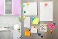 Many notes and empty sheets with magnets on refrigerator door in kitchen Royalty Free Stock Photo