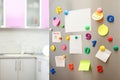 Many notes and empty sheets with magnets on refrigerator door in kitchen Royalty Free Stock Photo