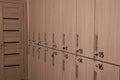 Many numbered wooden lockers with keys indoors