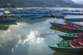 A many old blue green red wooden boats on the lake in the evening against the backdrop of the mountains Royalty Free Stock Photo