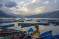 A many old blue green yellow red wooden boats on the lake in the evening against the backdrop of the mountains Royalty Free Stock Photo