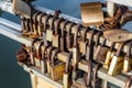 Many old rusty metal locks closed on fence of bridge over river. Love forever through time concept Royalty Free Stock Photo