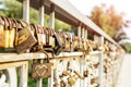 Many old rusty metal locks closed on fence of bridge over river. Love forever through time concept Royalty Free Stock Photo