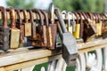 Many old rusty metal locks closed on fence of bridge over river. Love forever through time concept Royalty Free Stock Photo