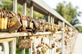 Many old rusty metal locks closed on fence of bridge over river. Love forever through time concept Royalty Free Stock Photo