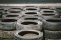 Many old used car tires stacked on top of each other on Automobile sports complex. Industrial landfill for the