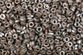 Many old used screw-nuts background, dark shining nuts