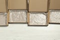 Many open cardboard boxes with bubble wrap on white wooden background, flat lay. Space for text Royalty Free Stock Photo