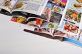 Many open magazines on white wooden table, above view Royalty Free Stock Photo