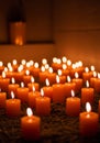 Many Orange Candles Glowing in the Dark Royalty Free Stock Photo