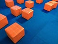 Many orange cubic padded stool chairs on blue carpet in event stage area inside of shopping mall Royalty Free Stock Photo
