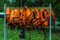 Many orange life jackets hang on a hanger in a row Royalty Free Stock Photo