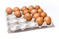 Many orange spotted brown chicken eggs in carton open box container on white back. One egg with black drawn smile face Royalty Free Stock Photo