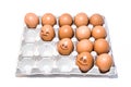 Many orange spotted brown chicken eggs in carton open box container on white background. Three eggs with emotion faces Royalty Free Stock Photo