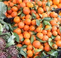 many orange tangerines with green leaves