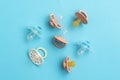 Baby pacifiers on blue background with copy space, top view of soothers, flat lay