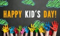 Many painted kids hands with smileys and the message `Happy Childrens Day` in German