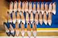 Many pairs of women's high heels set in three rows on a carpet. Fashion pumps with different designs. Royalty Free Stock Photo