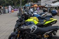 Many parked sport bikes stand in a line in the square