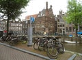Many parking bikes and Dutch traditional architecture along the canal in Amsterdam