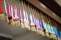 Many pastel color brushes hang on ropes from ceiling