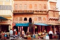 Many people buying food and spices in shops on historical street of indian city