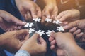 Many people hands holding a jigsaw puzzle in circle together