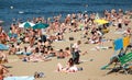 A crowded summer beach, people sunbathe in the sun and swim in the sea river, ocean