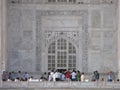 Many people at one of the entrances of the white marble mausoleum with four minarets and large domes. Taj Mahal