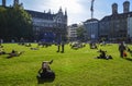 Many people relax on the grass and enjoying the sun on a green lawn at the Marienhof in the inner city of Munich