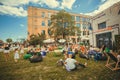 Many people relaxing with families on lawn during popular outdoor festival