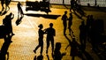 Many people silhouettes dancing on city embankment at sunset